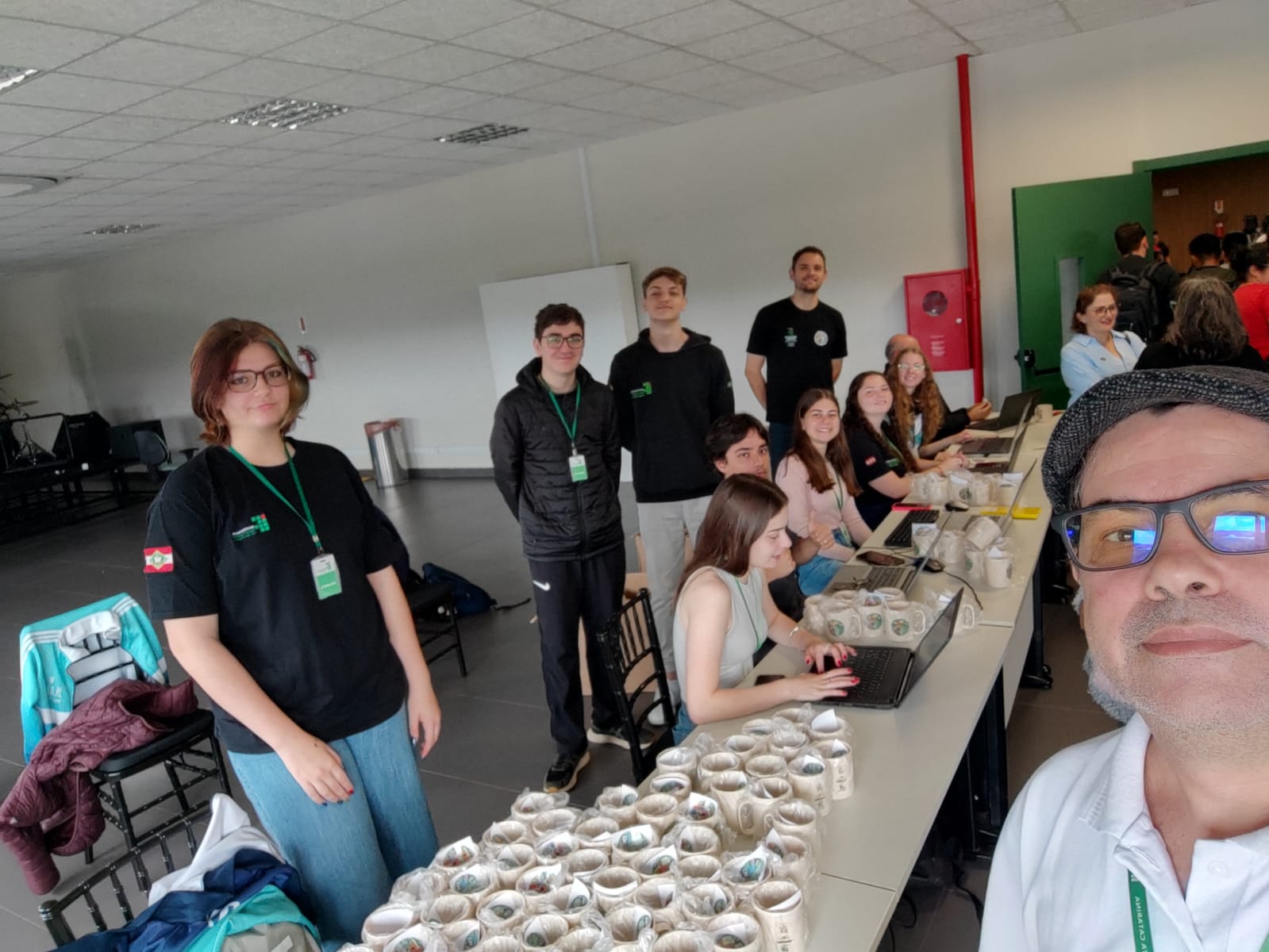 Professores e estudantes auxiliando no credenciamento e orientação aos participantes do evento