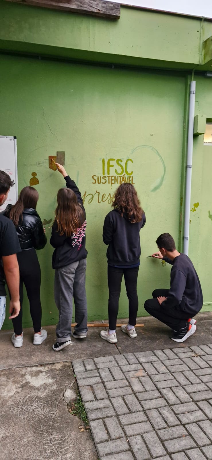 Pintura de painel com ecotintas junto à horta do câmpus.