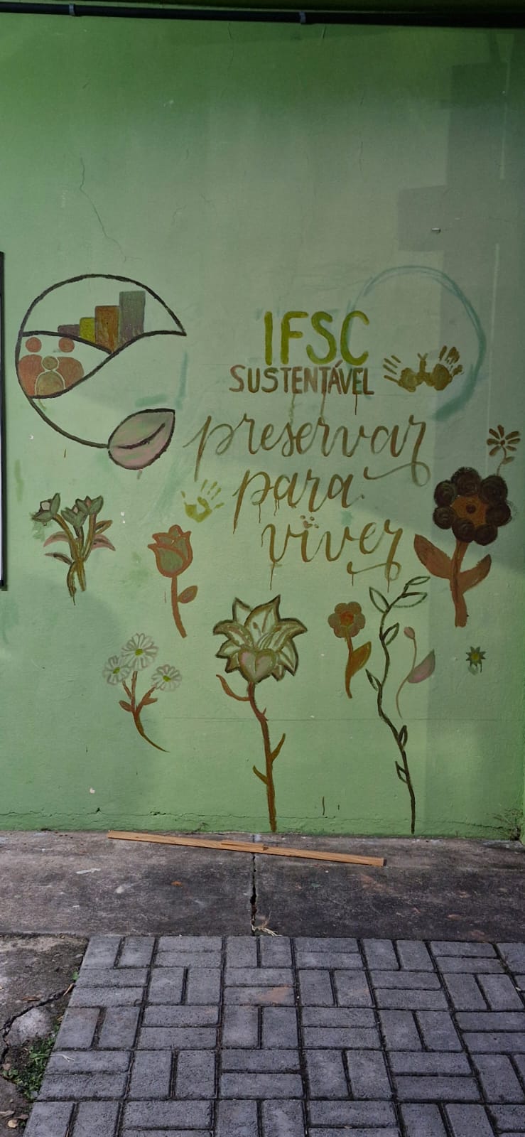 Pintura de painel com ecotintas junto à horta do câmpus.