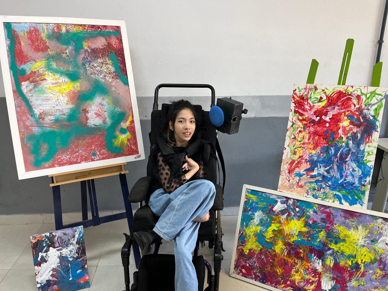 Júlia com seus quadros na exposição da Biblioteca