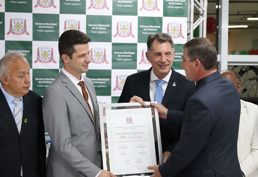 O diretor Geral Daniel Comin da Silva recebe a placa de aniversário dos 15 anos do Câmpus Criciúma pelas mãos do presidente da Câmara de vereadores Márcio Darós da Luz, acompanhado do reitor Zízimo Moreira Filho I Fotos: Edson Padoin / Câmara de vereadores de Criciúma