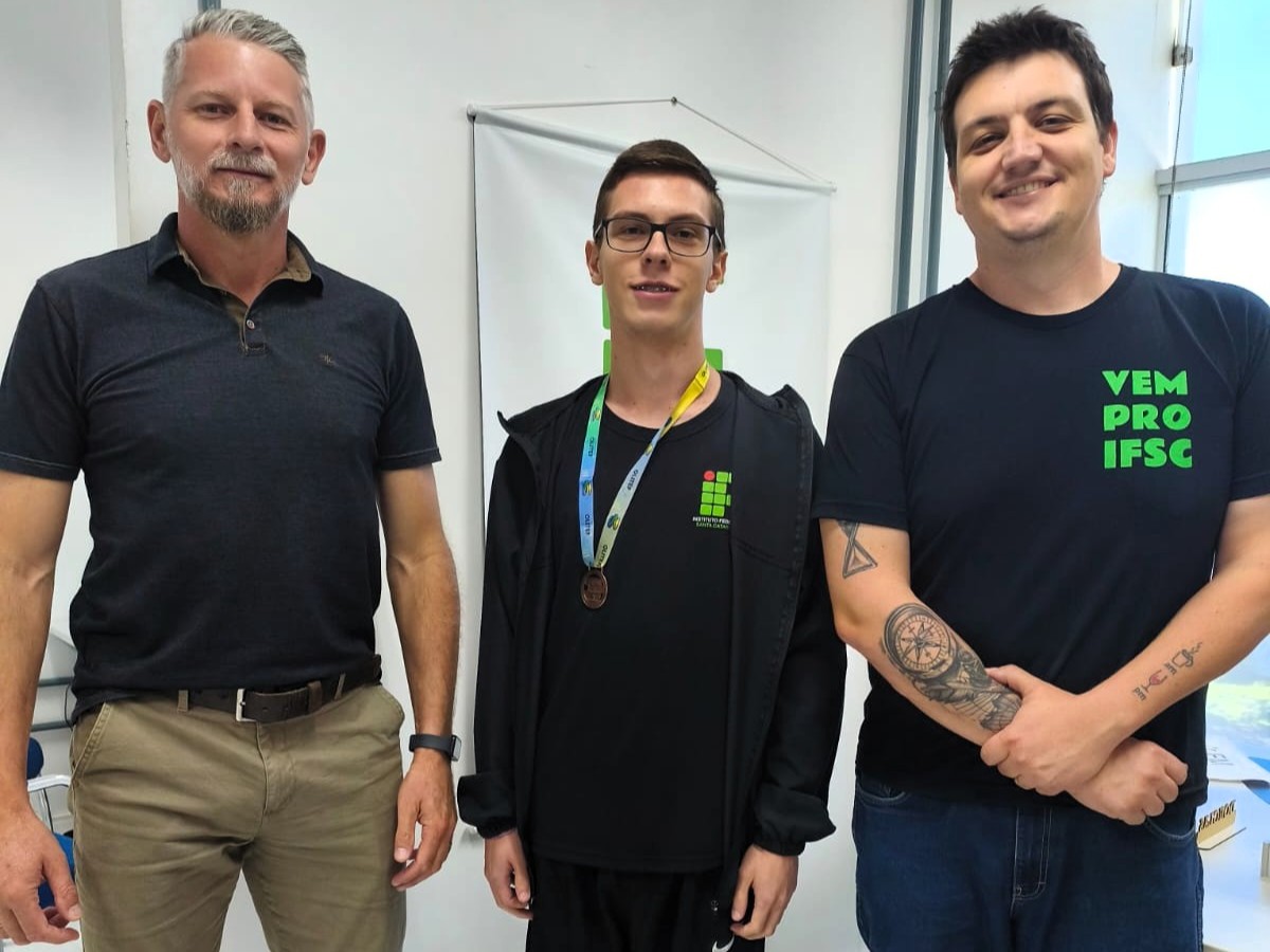 Ricardo, no centro, recebeu a medalha do professor Jefferson e do diretor Douglas Würz
