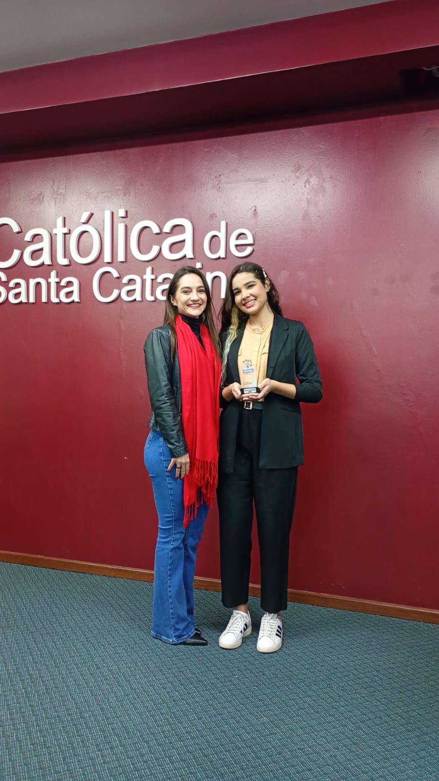Lavínia (à direita) acompanhada pela professora Bruna, após o resultado do concurso de oratória.
